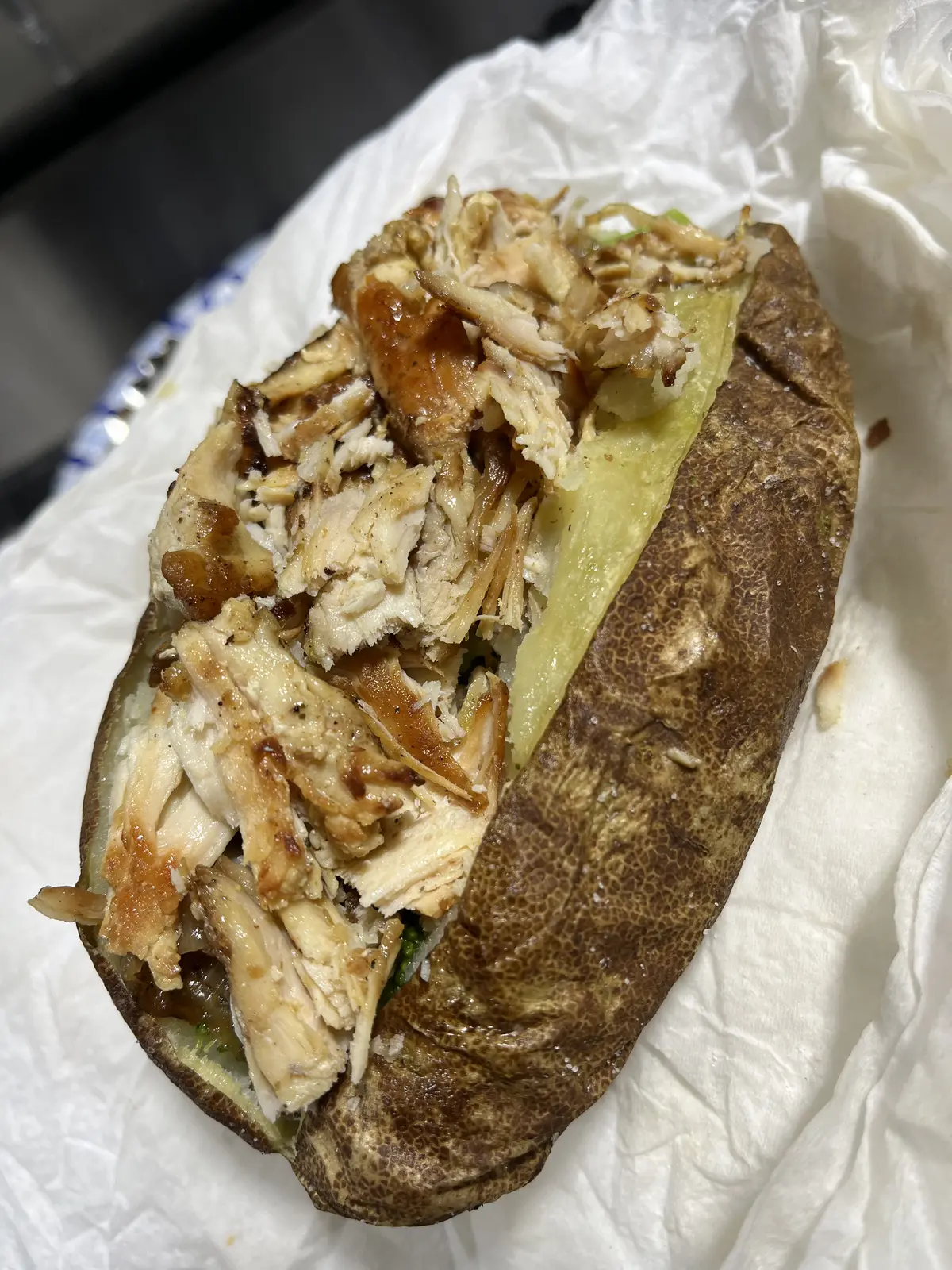 A loaded baked potato stuffed with seasoned chicken from the all-day menu at Dinner Is Served