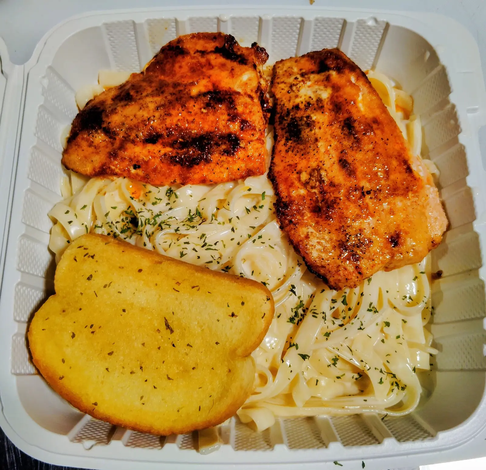 Chicken fettuccini alfredo with garlic bread at Dinner Is Served, a restaurant near North Shore Medical Center in Miami